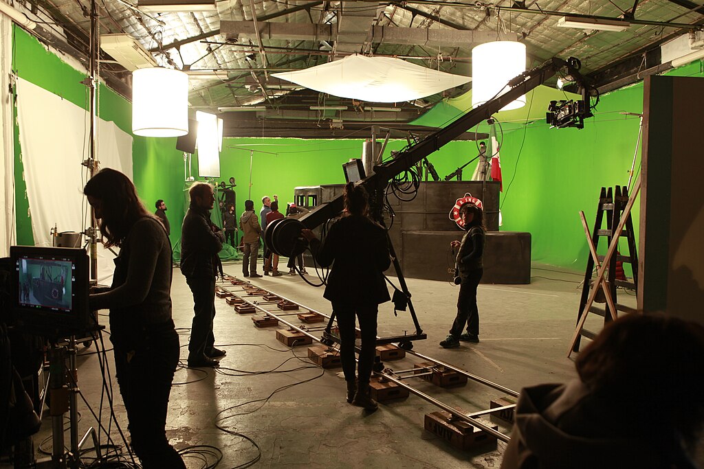 Film crew working on a movie set backstage with equipment and actors