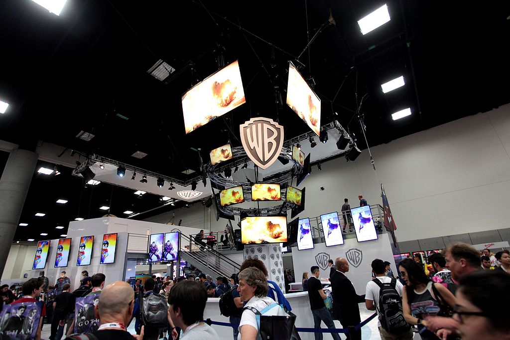 Warner Bros booth at San Diego Comic-Con 2015 with WB shield and multiple screens