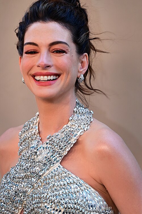 Anne Hathaway at a public appearance, smiling, photographed by Philip Romano