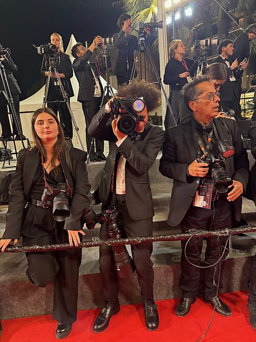 A photographer shooting on the Cannes Film Festival red carpet during the 2025 edition