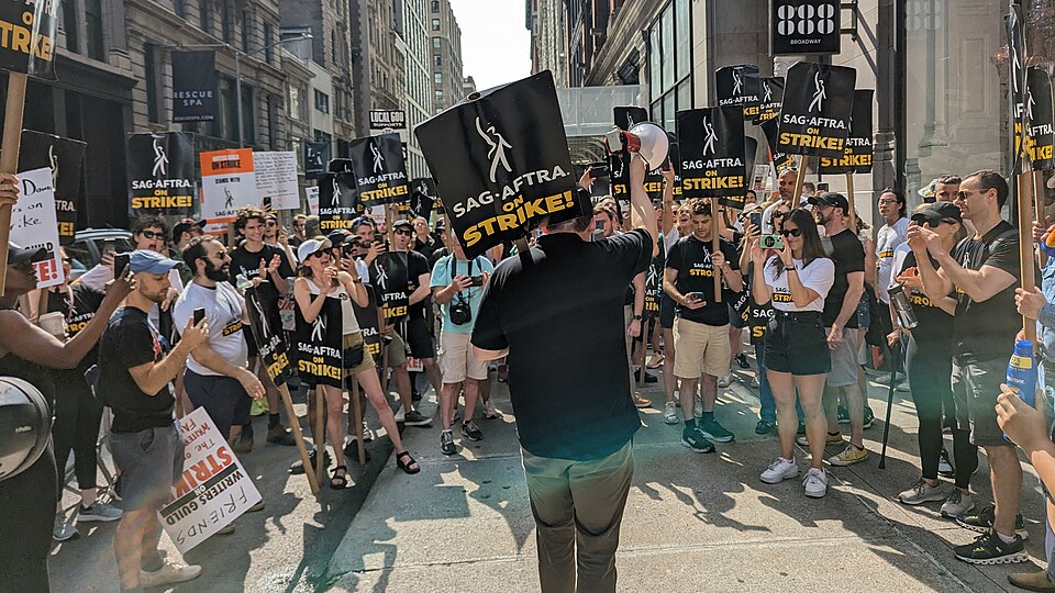 Actors and writers at a Hollywood picket rally holding union signs