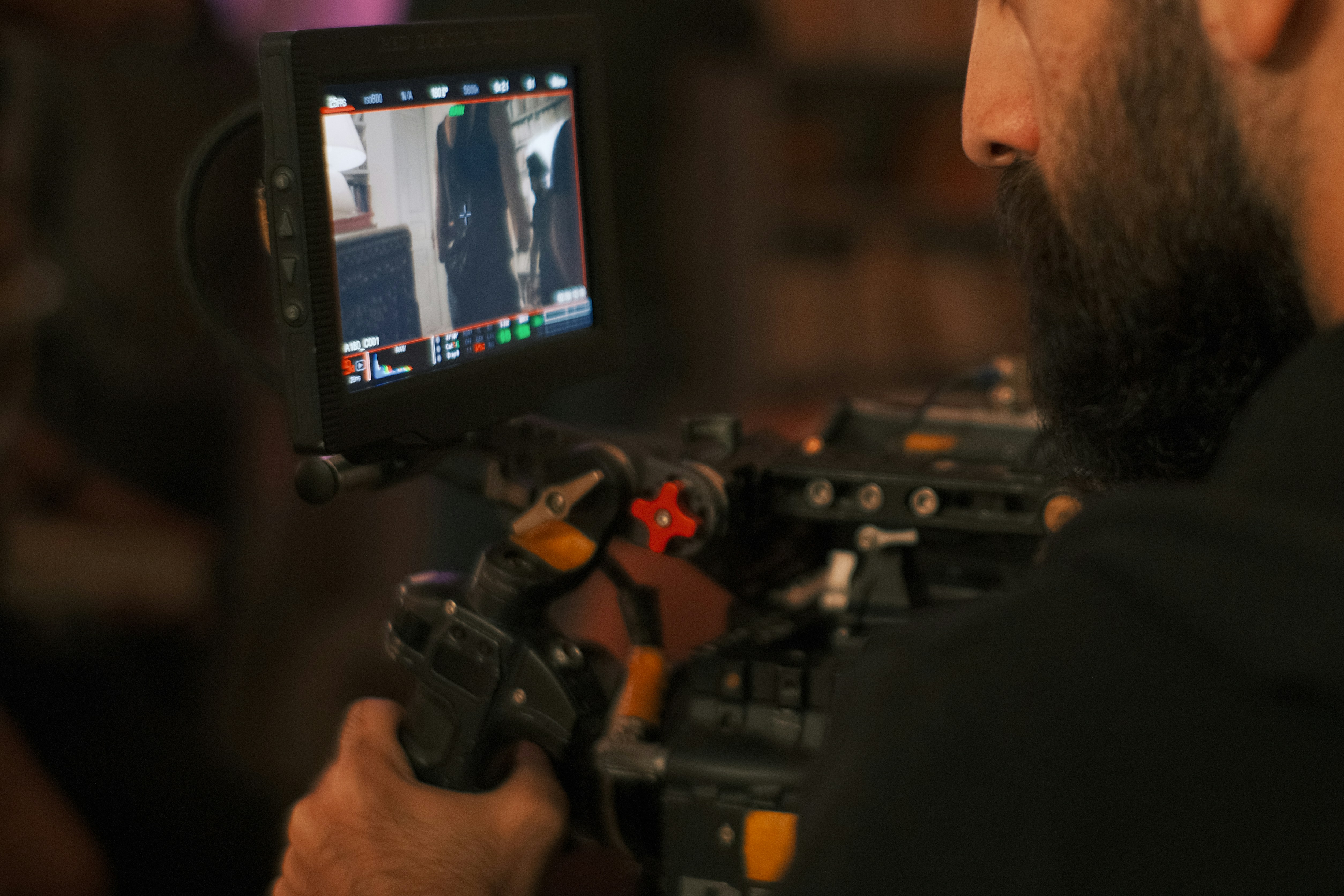 Cinematographer operating professional camera equipment on film set