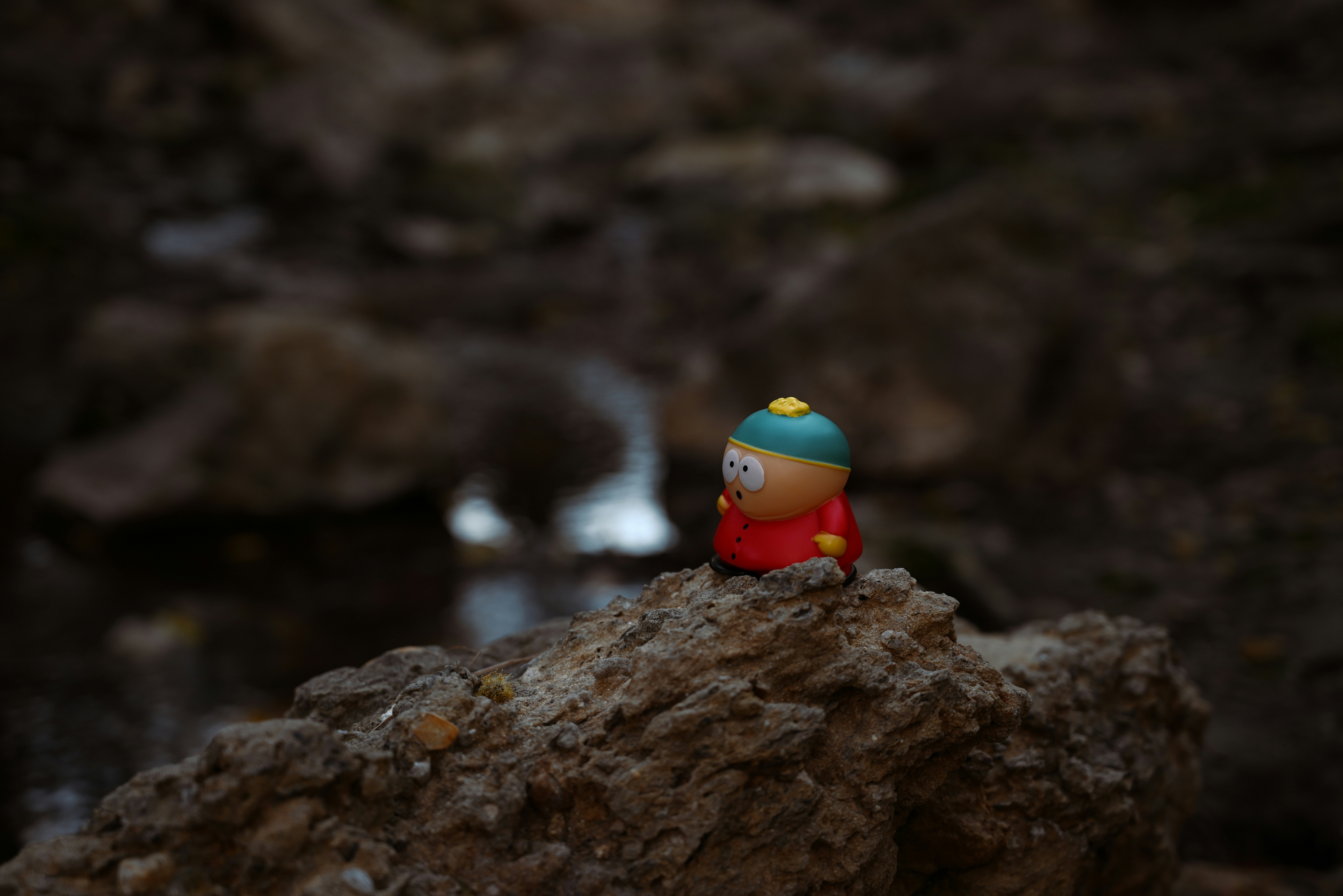 Small toy figure balanced on a rock
