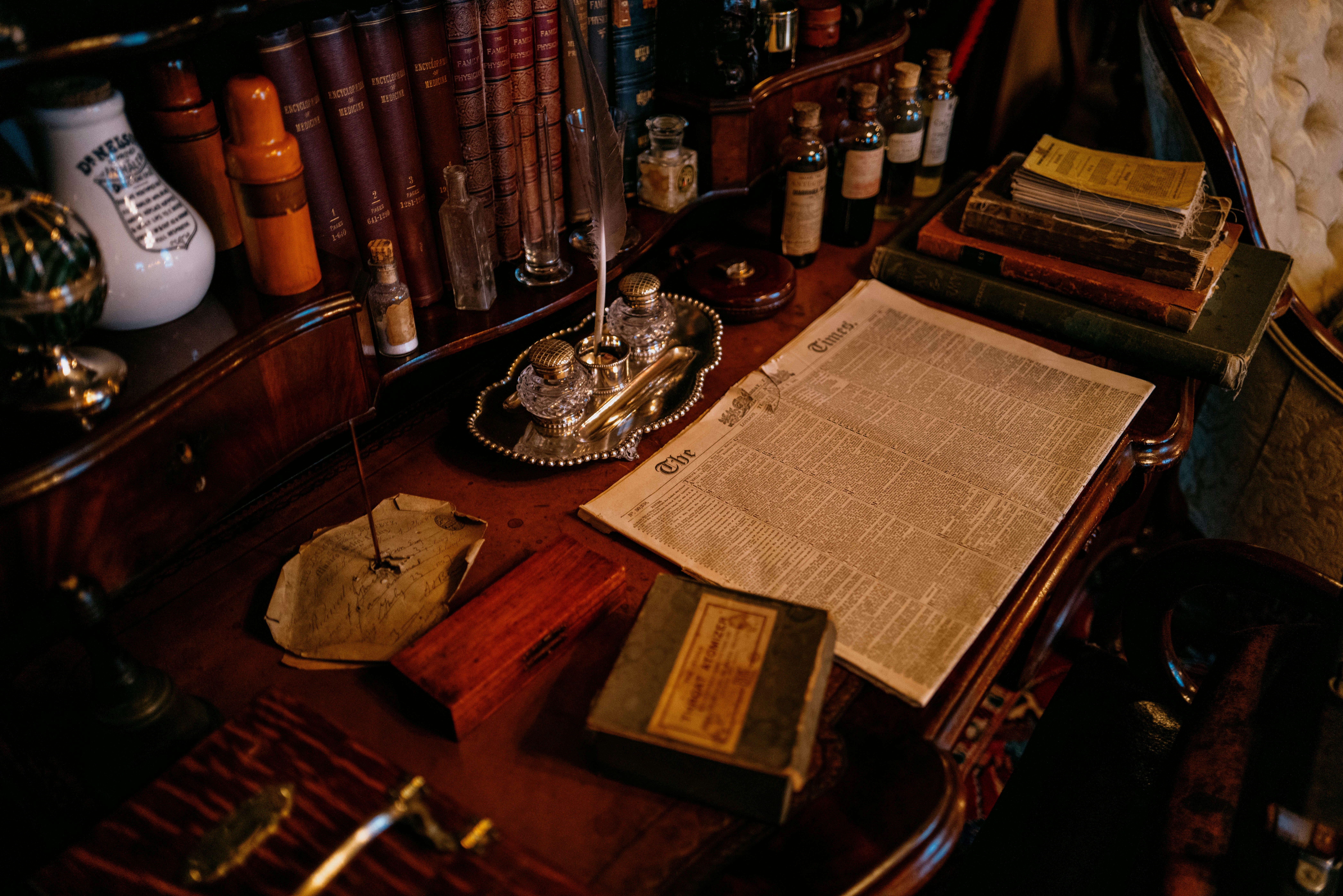 Old writing desk with inkwell, papers, and books