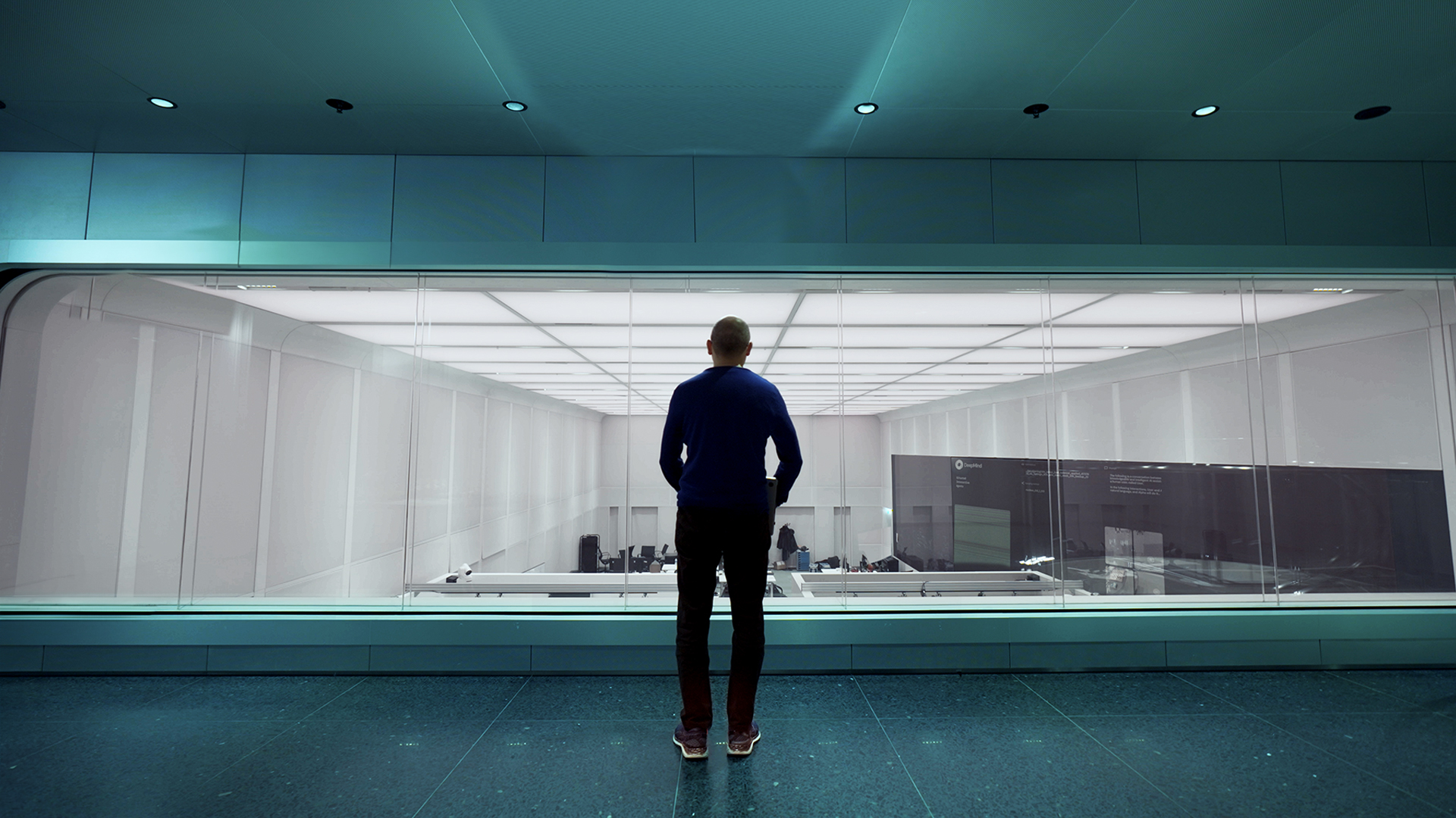 Researcher standing in DeepMind headquarters observing workspace